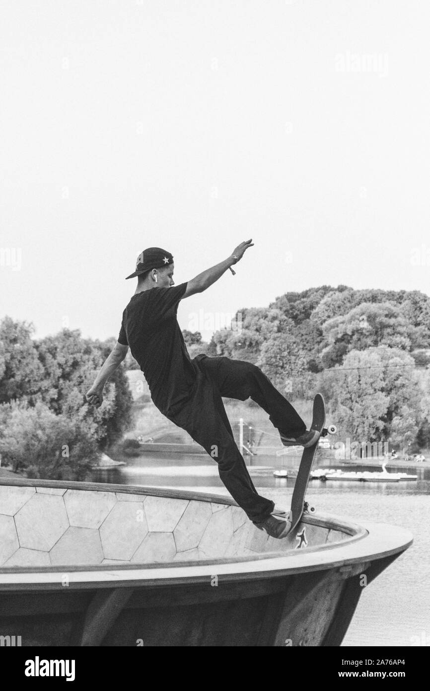 Lo skateboarder professionista facendo un trucco in bianco e nero Foto Stock