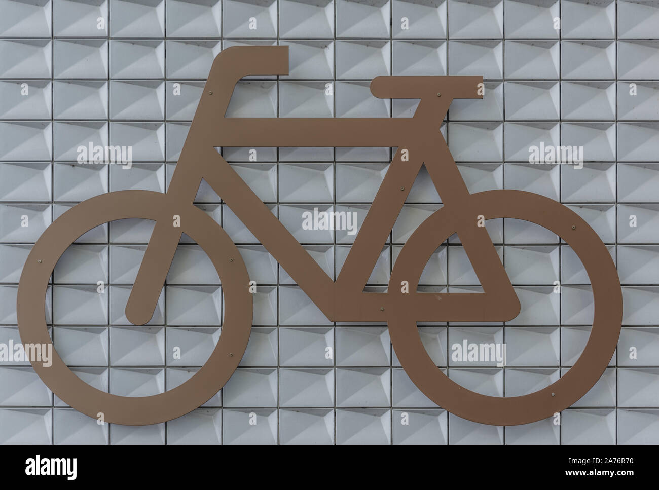 Grande parcheggio biciclette avvitato al grande muro di pietra Foto Stock