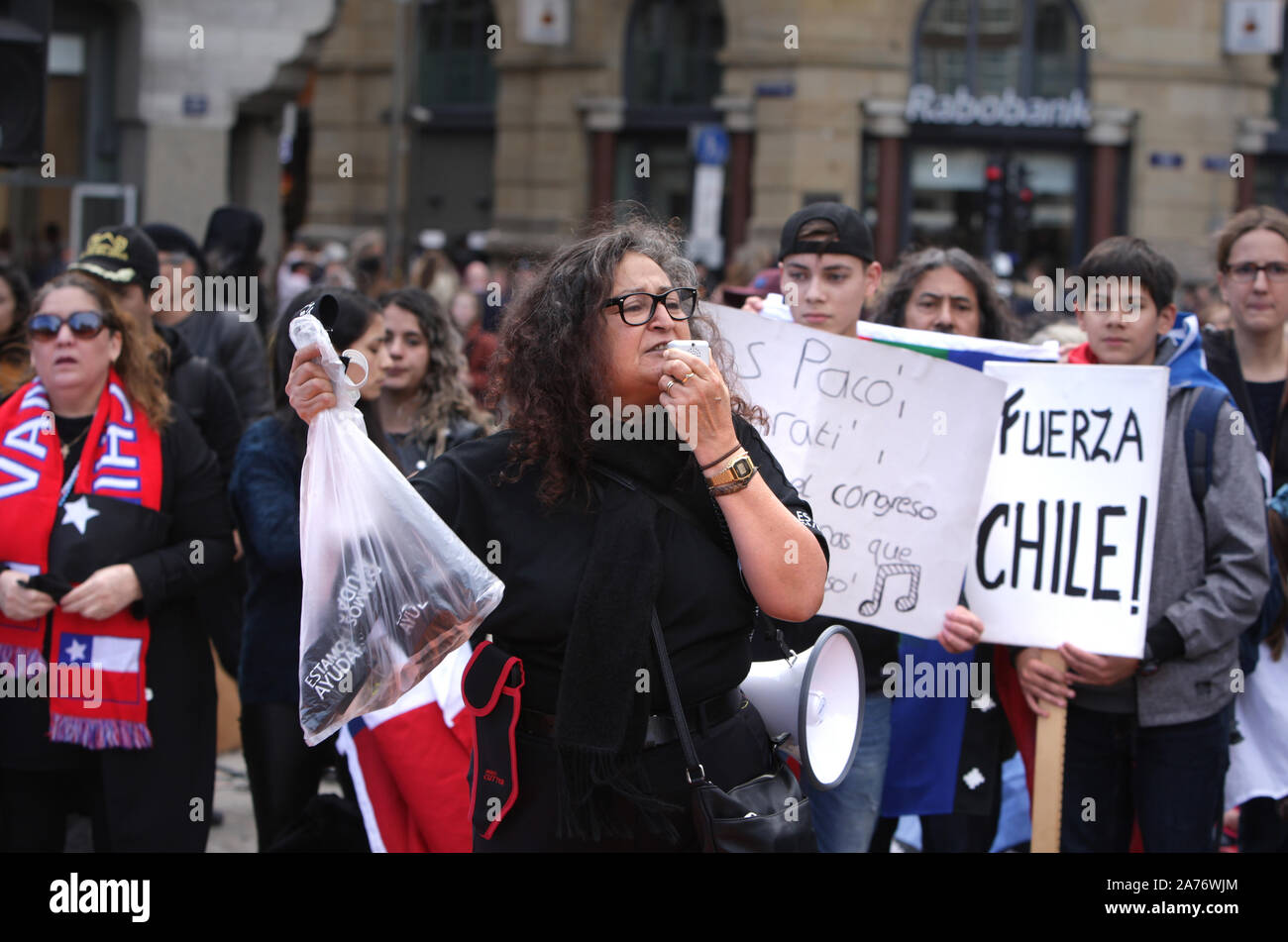 I membri della comunità cilena protesta in piazza Dam in ottobre 26, 2019 in Amsterdam, Paesi Bassi. Presidente Sebastian Piñera ha annunciato misure Foto Stock