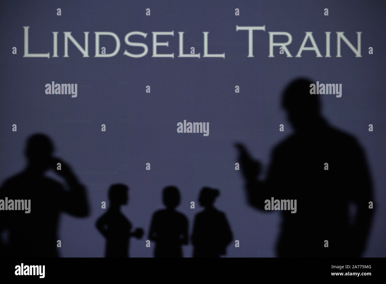 Il treno di Lindsell logo è visibile su uno schermo a LED in background mentre si profila una persona utilizza uno smartphone (solo uso editoriale) Foto Stock