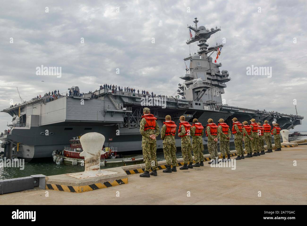 191030-N-PW480-0077 NORFOLK,Va. (Ott. 30, 2019) marinai del Nimitz-Class portaerei USS Harry Truman in stand by per ricevere le linee dalla Ford-Class portaerei USS Gerald Ford (CVN 78) come essa tira in Naval Station Norfolk su Ott. 30. Ford ha restituito al mare per la prima volta dall inizio il suo post-shakedown disponibilità in luglio 2018 per condurre le prove in mare. Foto Stock