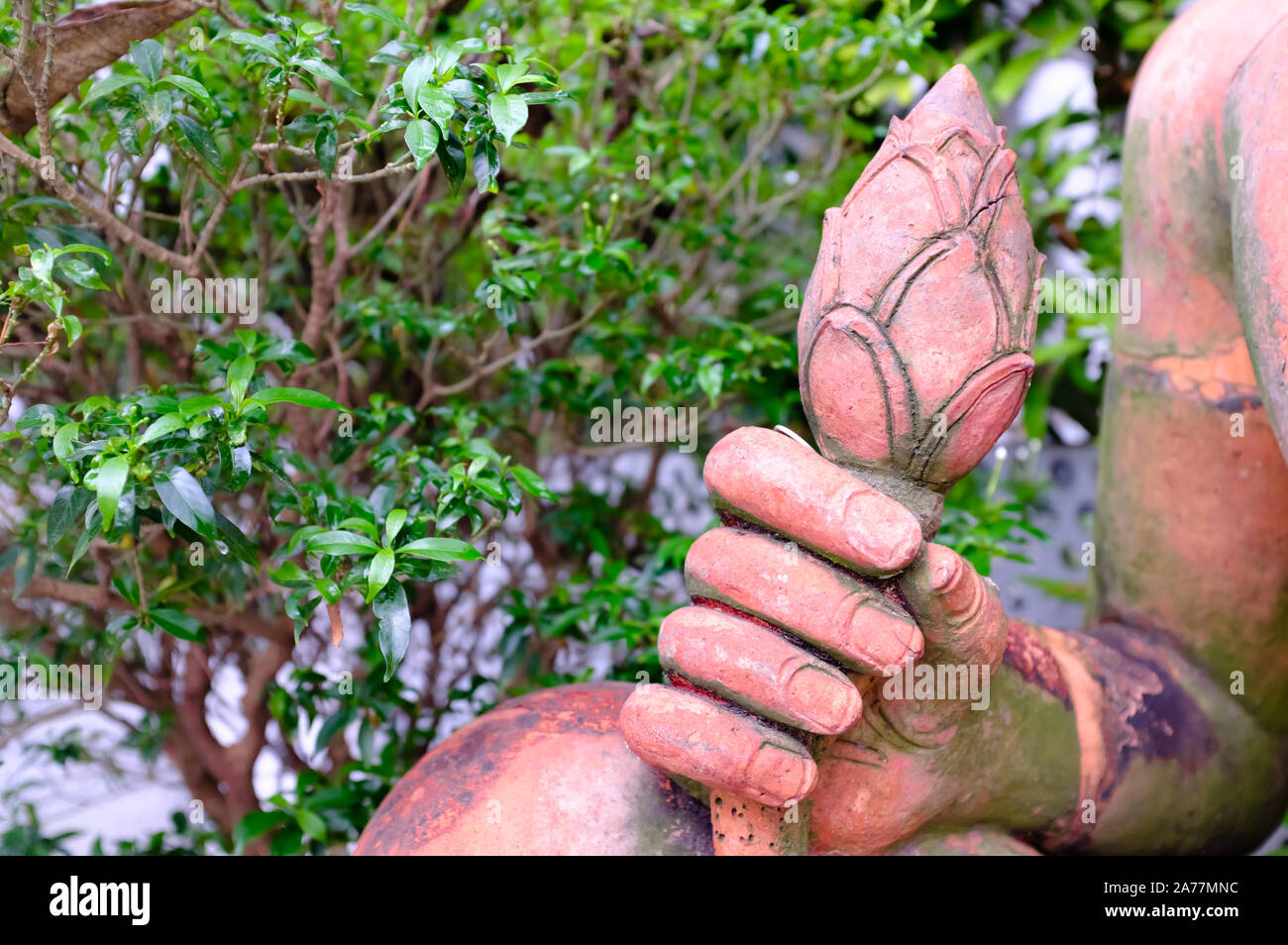 Buddha scultura in pietra mano closeup vista,tenendo una gemma di loto Foto Stock