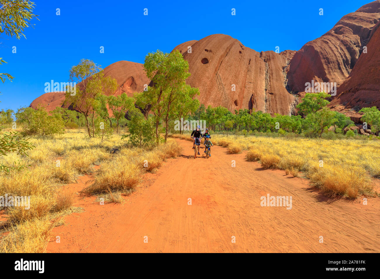 Uluru, territorio del Nord, Australia - 24 agosto 2019: Visita della famiglia Ayers Rock con giro in bicicletta lungo la passeggiata della base di Uluru a Uluru-Kata Tjuta Foto Stock
