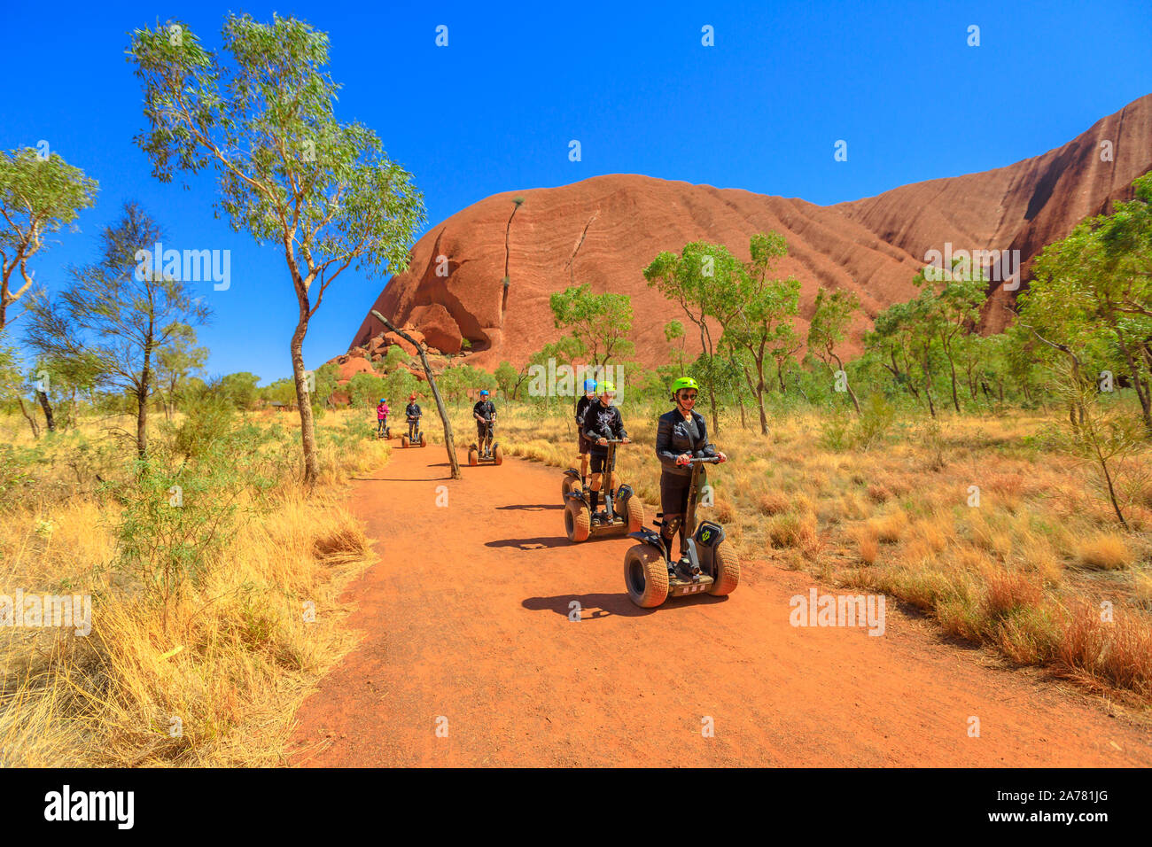 Uluru, Territorio del Nord, Australia - 24 AGO 2019: la gente visita Ayers Rock con la Uluru Segway Tours lungo la base di Uluru, Passeggiata nel sentiero di sabbia di Uluru-Kata Foto Stock