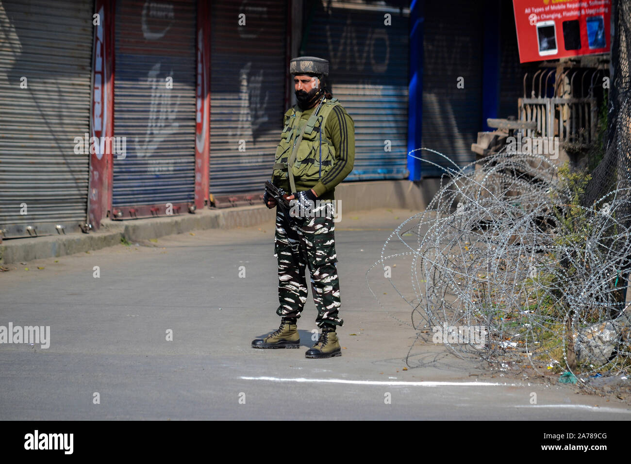Un soldato di paramilitari sorge in guardia durante lo shutdown.valle del Kashmir hanno continuato a rimanere chiuso sulla 88th giorno consecutivo contro l'abrogazione dell'articolo 370 e la biforcazione del Jammu e Kashmir Stato in due territori dell'Unione da parte del governo indiano. Foto Stock