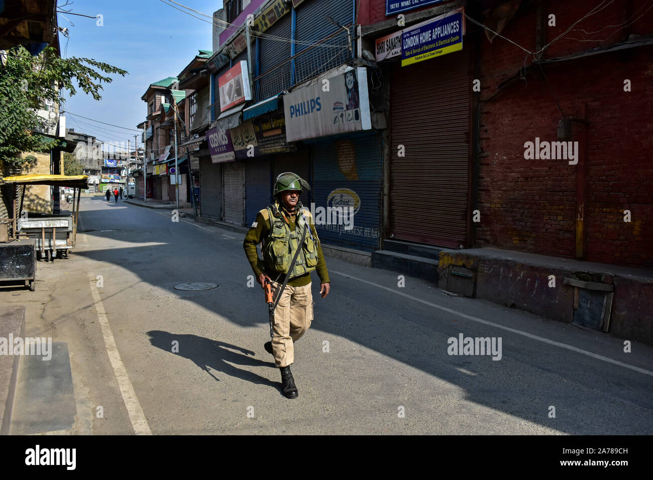 Un soldato di paramilitari delle pattuglie una strada durante lo shutdown.valle del Kashmir hanno continuato a rimanere chiuso sulla 88th giorno consecutivo contro l'abrogazione dell'articolo 370 e la biforcazione del Jammu e Kashmir Stato in due territori dell'Unione da parte del governo indiano. Foto Stock