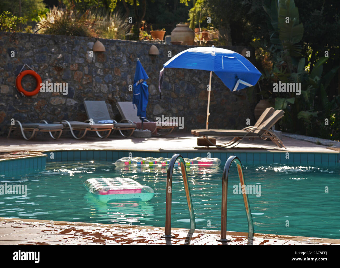 Vista di svuotare la piscina con materassini gonfiabili galleggianti e spruzzi d'acqua piastrelle sul bordo. Concetto: piscina sicurezza. Foto Stock