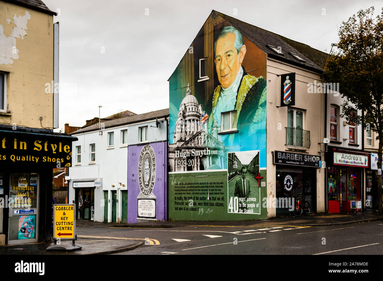 Un murale sulla Shankill Road, Belfast, Irlanda del Nord, raffigura il politico Hugh Smyth OBE (1939–2014) nelle vesti di sindaco del Lord Mayor di Belfast davanti alla cupola del Belfast City Hall, con l'iscrizione "40 anni di servizio per la gente di Shankill". Smyth è stato Lord Mayor di Belfast dal 1994 al 1995 e ha guidato il Partito Unionista Progressista dal 1979 al 2002 (con un breve periodo intermedio nel 2011). Foto Stock