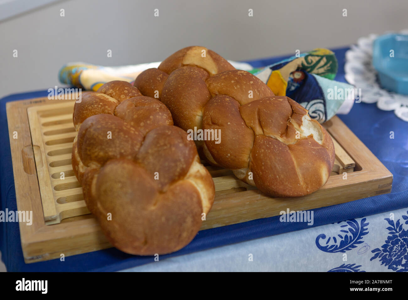 Jewish challah pane giacente su una tavola di legno e la tovaglia prima di Shabbat Foto Stock