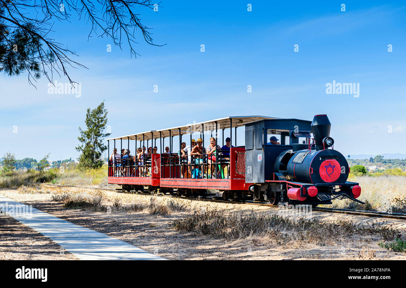 Trasporto passeggeri con ferrovia panoramica in miniatura che porta passeggeri a Baril Beach, Santa Luzia, East Algarve, Portogallo. Foto Stock