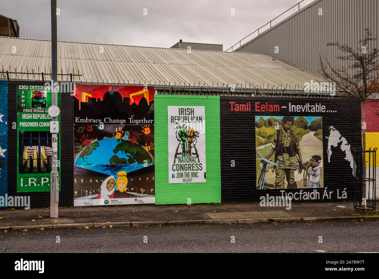 Un murale intitolato "Tamil Eelam – Inevitabile" sull'International Wall, Northumberland Street, Belfast, Irlanda del Nord, mostra un combattente armato accanto a un bambino insieme allo slogan repubblicano irlandese "Tiocfaidh ár lá" ("Il nostro giorno verrà"); alla sua sinistra, i murales chiedono il rilascio dei repubblicani irlandesi imprigionati ("Fine dell'internamento", Comitato dei prigionieri repubblicani irlandesi) e promuovono il Congresso nazionale repubblicano irlandese, con un murale intitolato "Abbraccia il cambiamento insieme" nel mezzo. Foto Stock