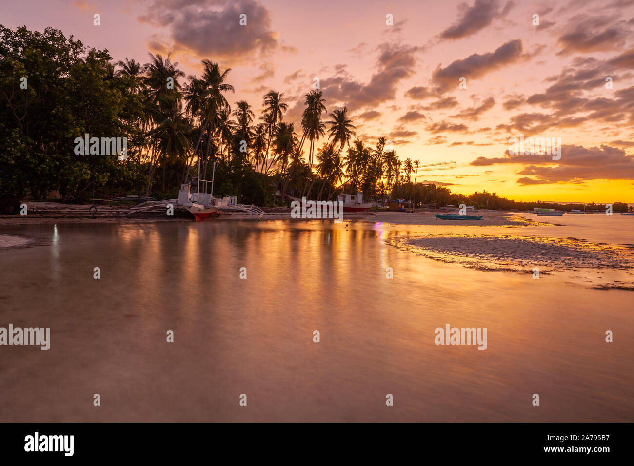 Tradizionale Bangka filippino barche su una spiaggia al tramonto, Panglao, Filippine Foto Stock