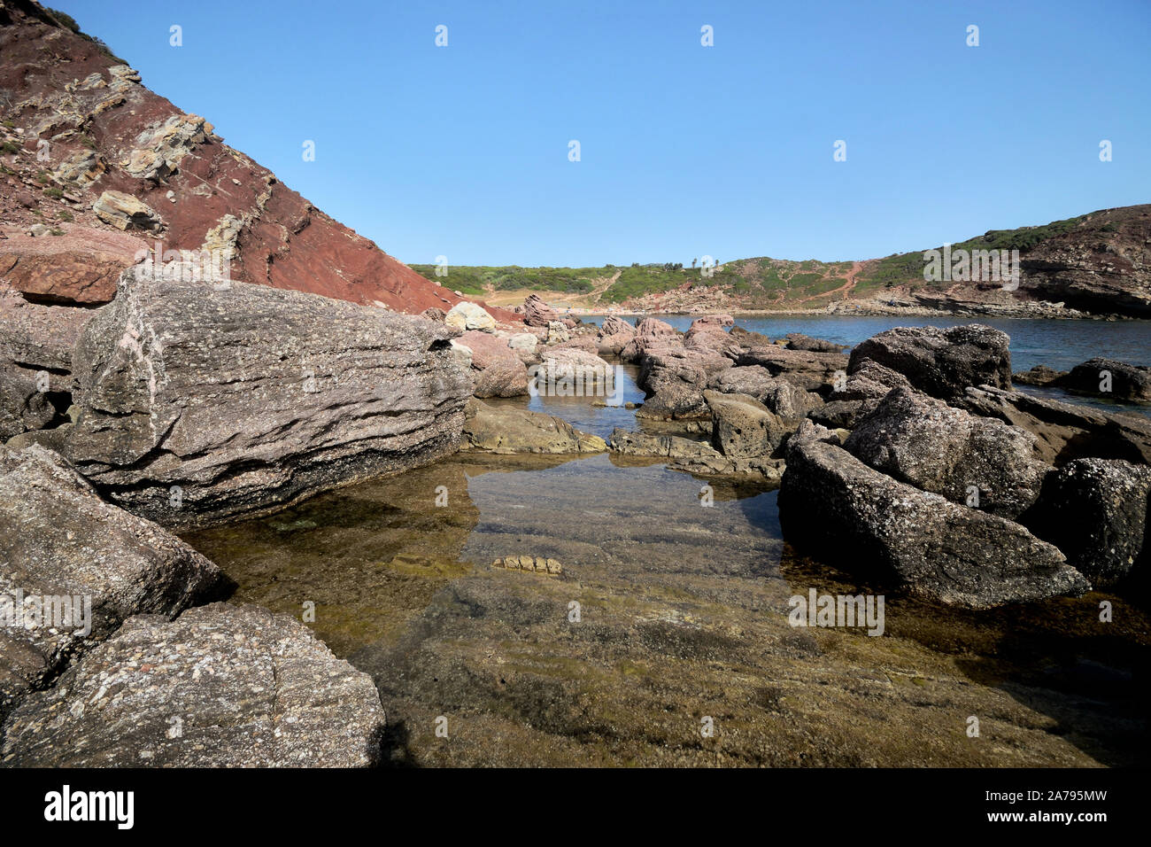 Le splendide scogliere di Torre di Porticciolo spiaggia vicino ad Alghero su una soleggiata giornata estiva Foto Stock