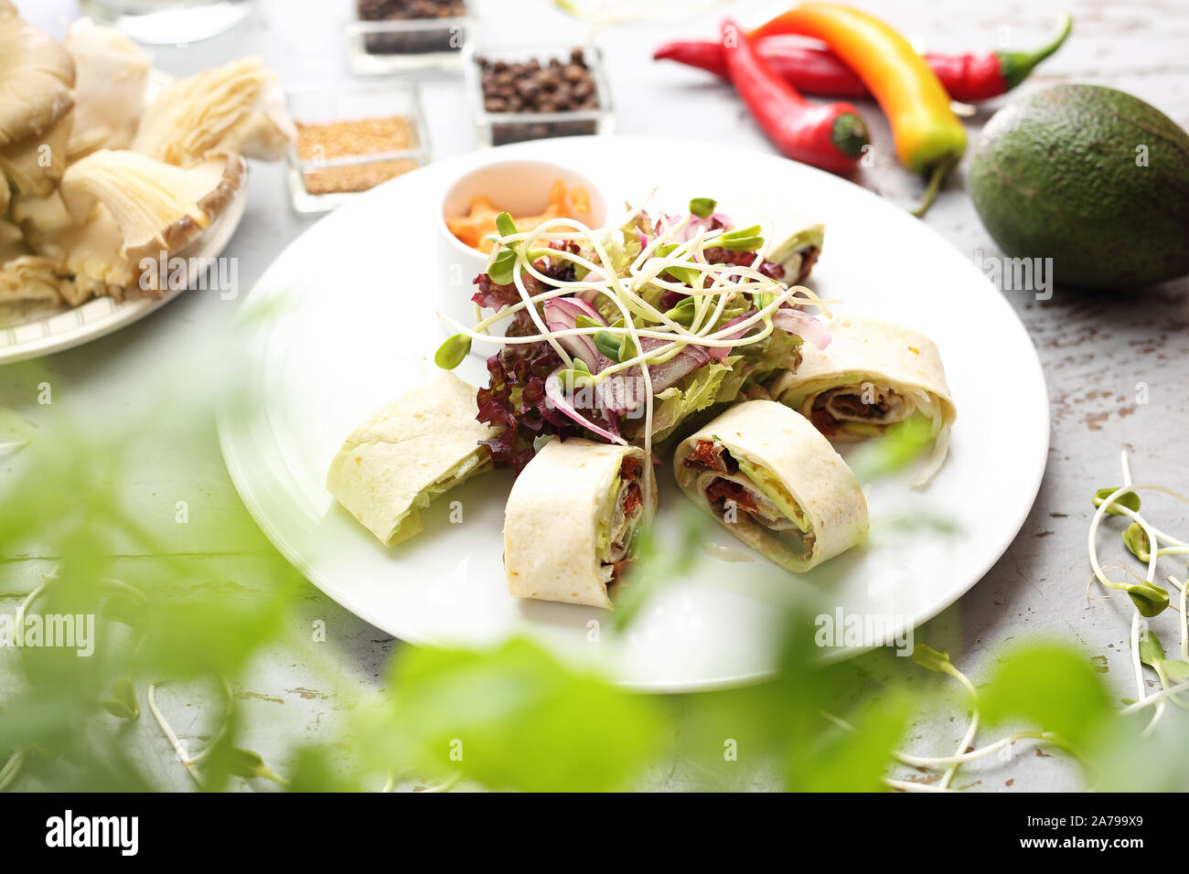 Tortilla rotoli - riempimento con lattuga iceberg, avocado, pomodoro secco e caramellato oyster fungo con salsa maionese. Foto Stock