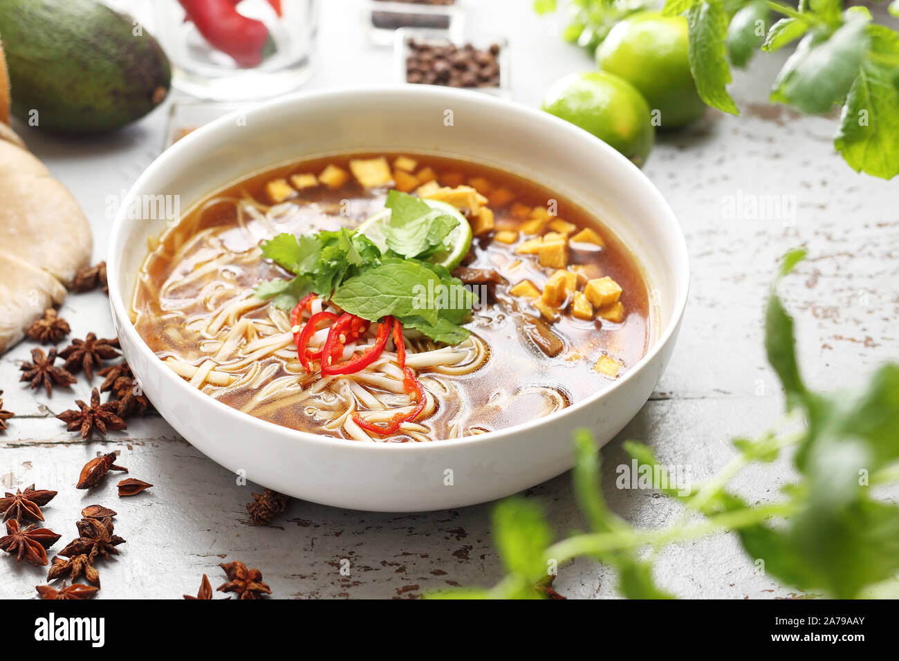 Piccante zuppa Pho con la menta, coriandolo, tofu, caramellato funghi orecchioni, calce, riso tagliatelle e peperoncino. Oriental zuppa vietnamita Foto Stock