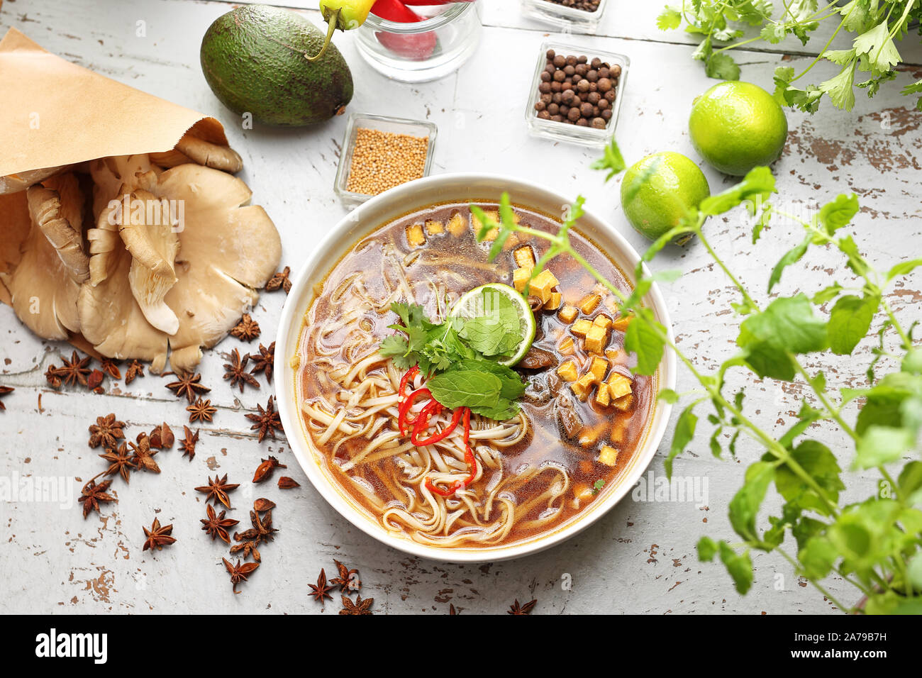 Zuppa PHO con la menta, coriandolo, tofu, caramellato funghi orecchioni, calce, riso tagliatelle e peperoncino. Oriental zuppa vietnamita Foto Stock