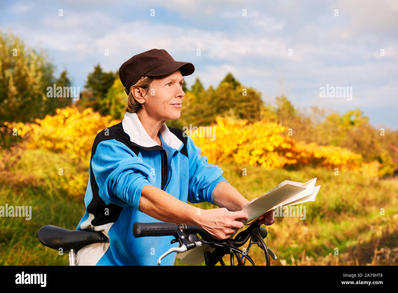 Senior ciclista controlla il percorso sulla mappa stradale Foto Stock