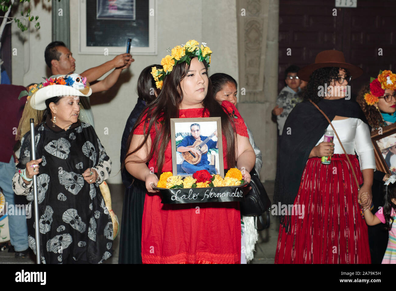 Los Angeles, California/USA - Ottobre 30, 2019: una donna tiene un piccolo altare in onore di una persona cara al Giorno dei Morti celebrazione a Olvera Street Foto Stock