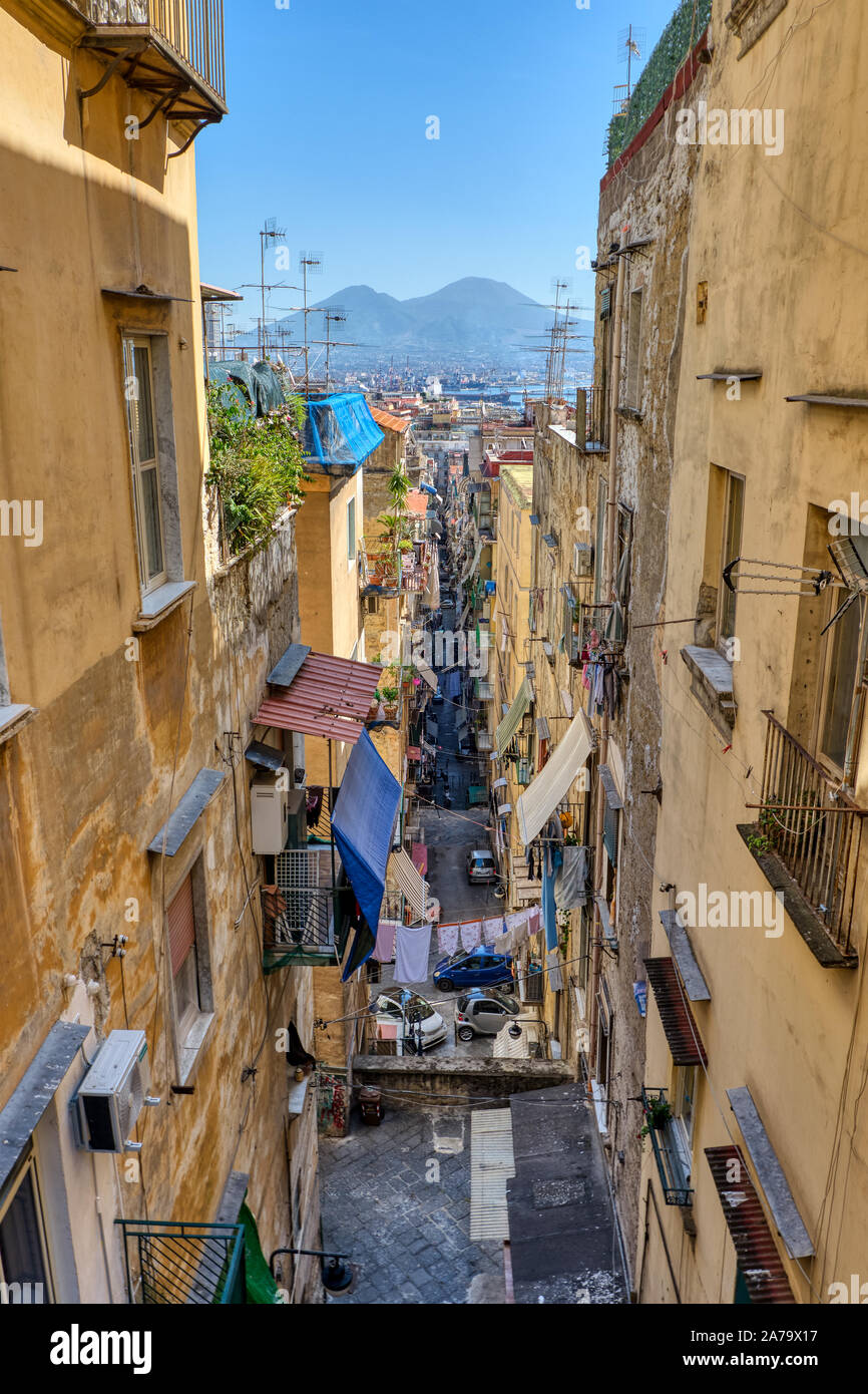 Stretto vicoletto nel centro storico della città di Napoli con il Vesuvio nel retro Foto Stock