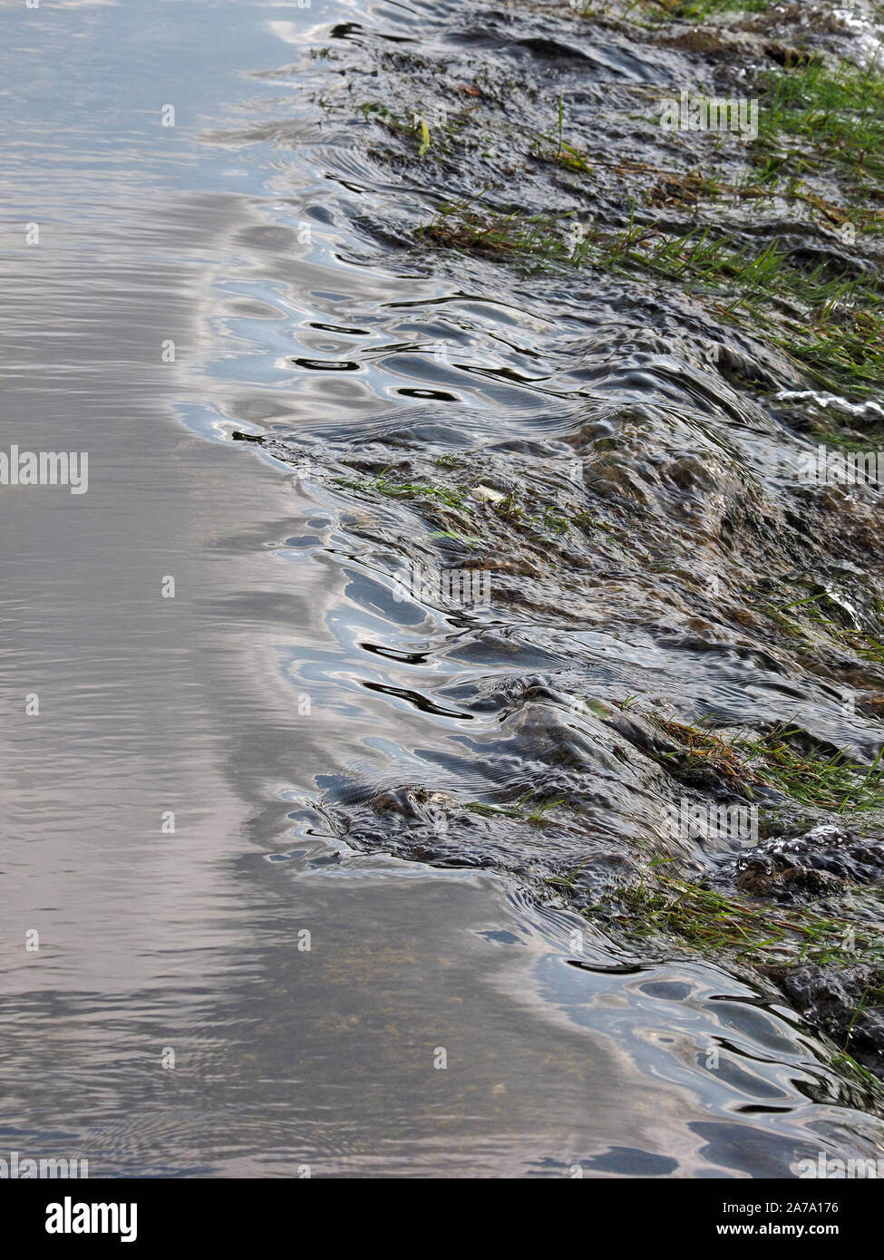 Il punto in cui acqua liscia si rompe in un torrente che ondeggia in corrispondenza del bordo di uno stramazzo sul fiume Lyvennet in Maulds Meaburn in Cumbria,l'Inghilterra,UK Foto Stock