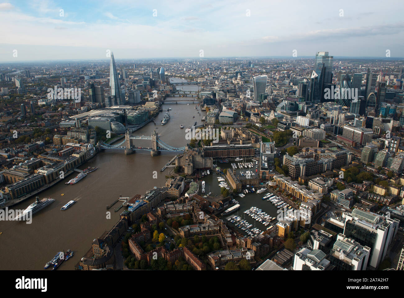 Una veduta aerea della città di Londra con il Tower Bridge e il Molo di St Katherines in primo piano. Foto Stock