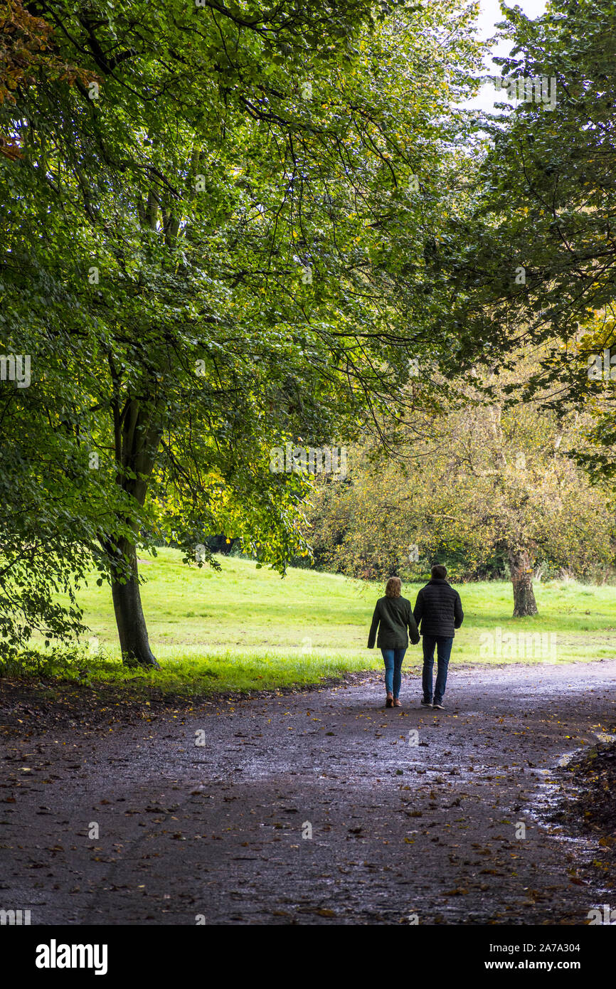 Sefton Park, un paio a piedi lungo un sentiero in autunno, Liverpool, England, Regno Unito Foto Stock