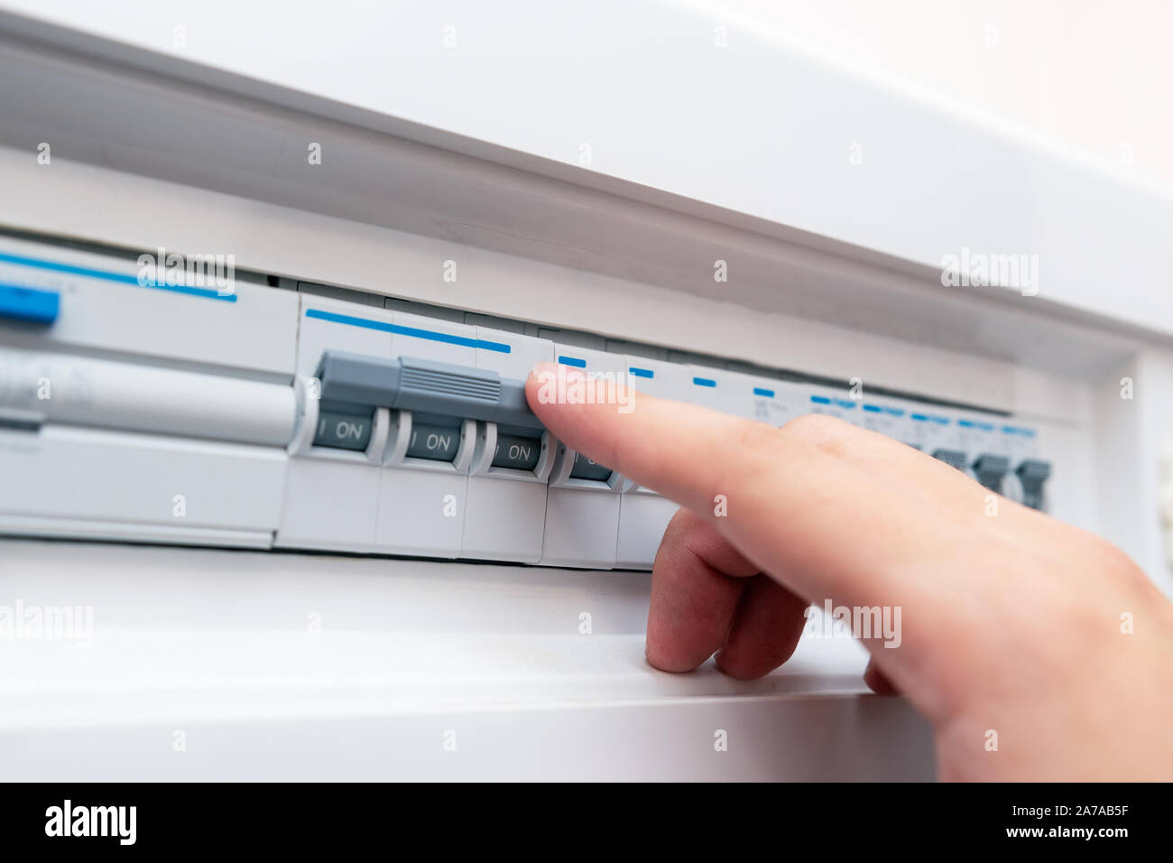 L'uomo disabilita i fusibili corrente. I dispositivi elettrici di protezione Foto Stock