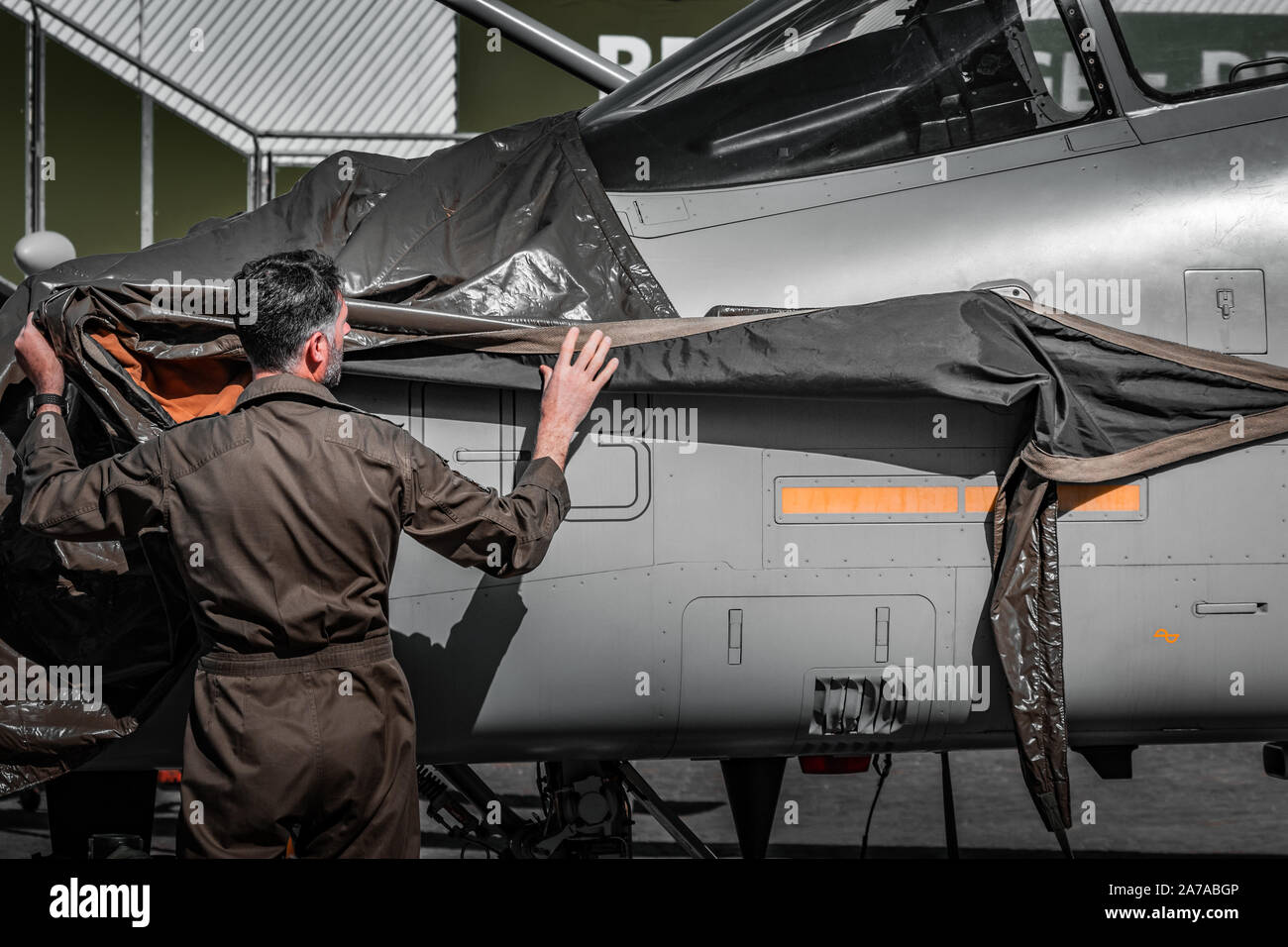 Italian Air Force jet. Al di fuori di hangar per la manutenzione, corpo grigio, la luce naturale del giorno, verde uniforme militare. Vita militare nel 2019. Foto Stock