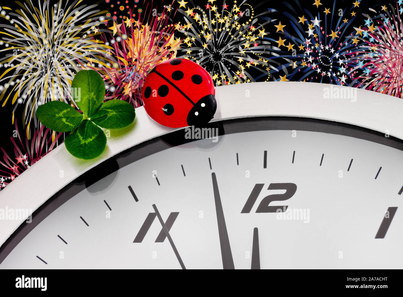 Concetto di festa di Capodanno con orologio e fuochi d'artificio Lucky Clover come sfondo Foto Stock