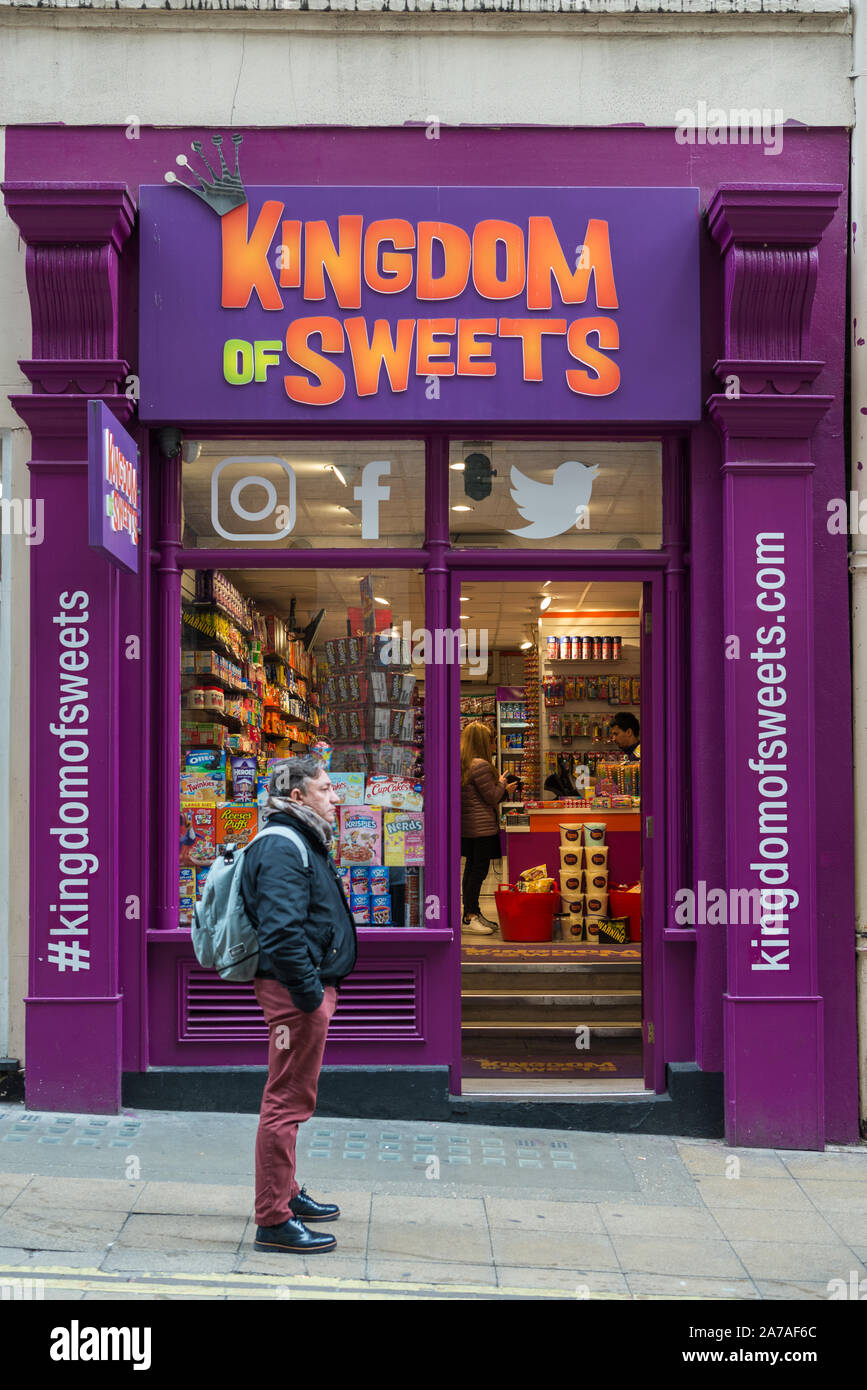 L uomo sta al di fuori del Regno di dolci pasticceria in Villiers Street, Charing Cross a Londra, Inghilterra, Regno Unito Foto Stock