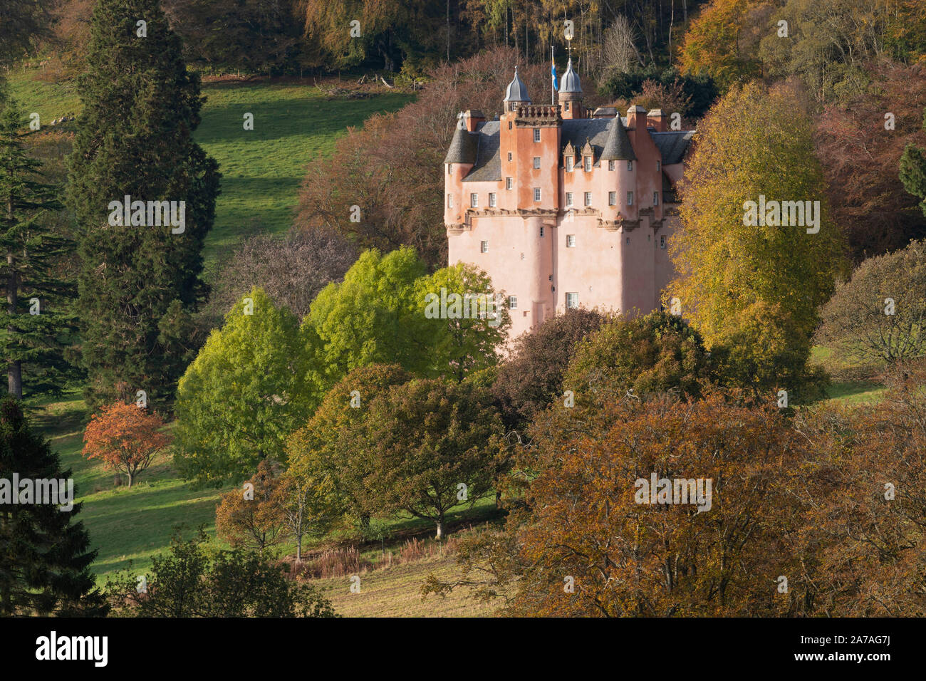 I colori degli alberi in autunno in Aberdeenshire integrano le pareti rosa di Craigievar Castle Foto Stock