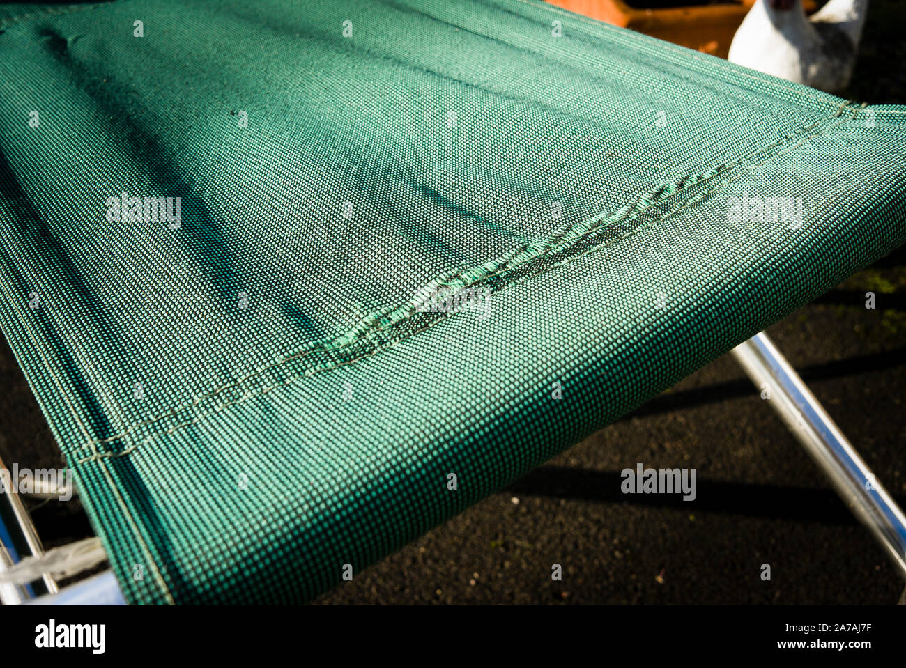 Il tessuto di un pieghevole sedia da giardino mostra il deterioramento rendendolo pericoloso per un ulteriore utilizzo Foto Stock