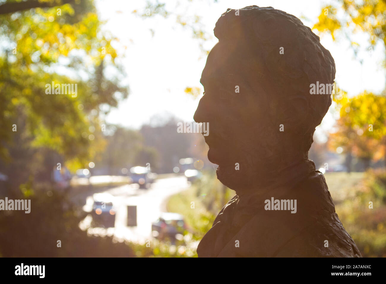 Silhouette della statua di bronzo di Mihaly Tompa poeta ungherese con il traffico urbano in background, Sopron, Ungheria Foto Stock