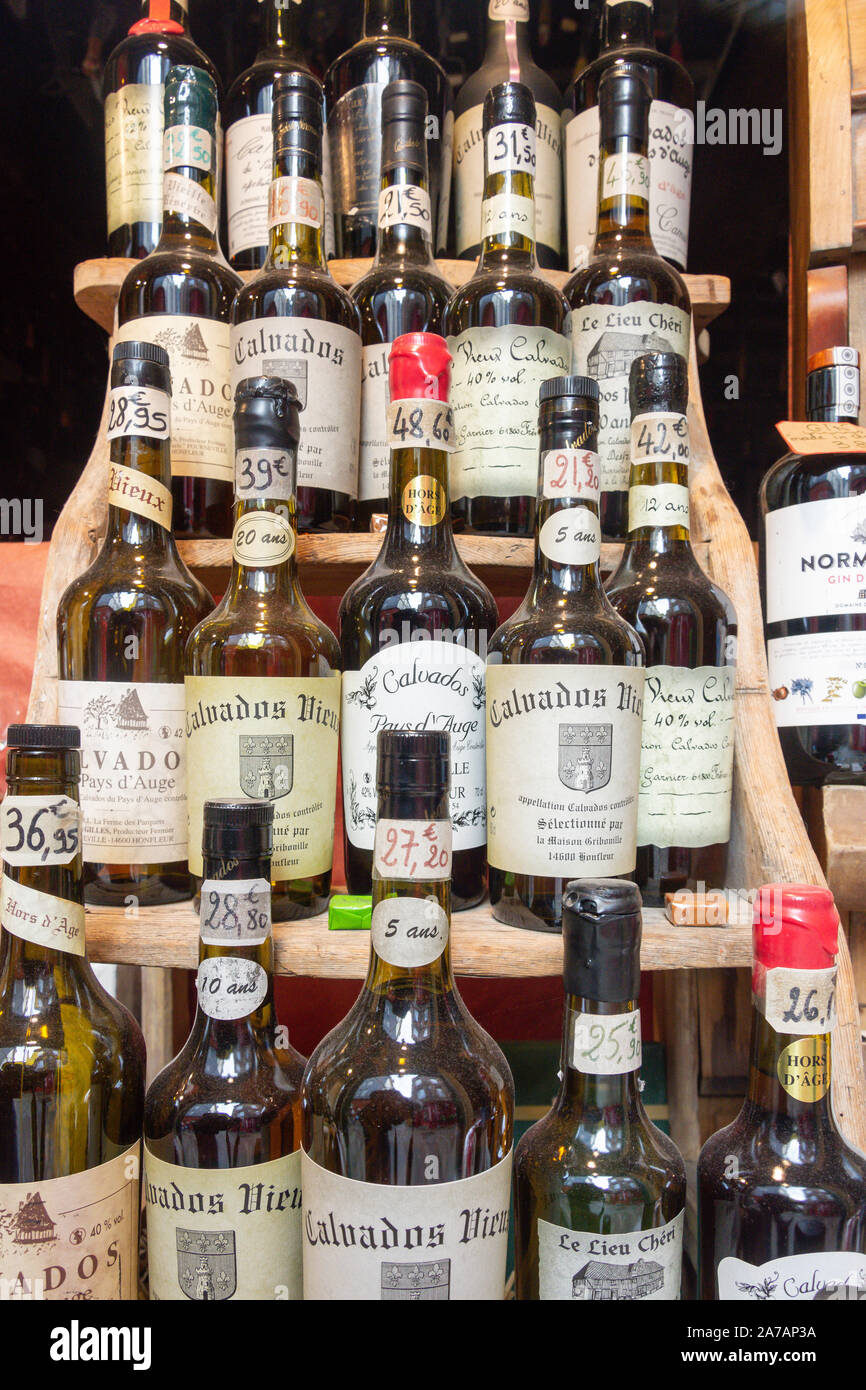 Bottiglie di età compresa tra il Calvados Brandy in vetrina, Place de Catherine, Honfleur, Normandia, Francia Foto Stock