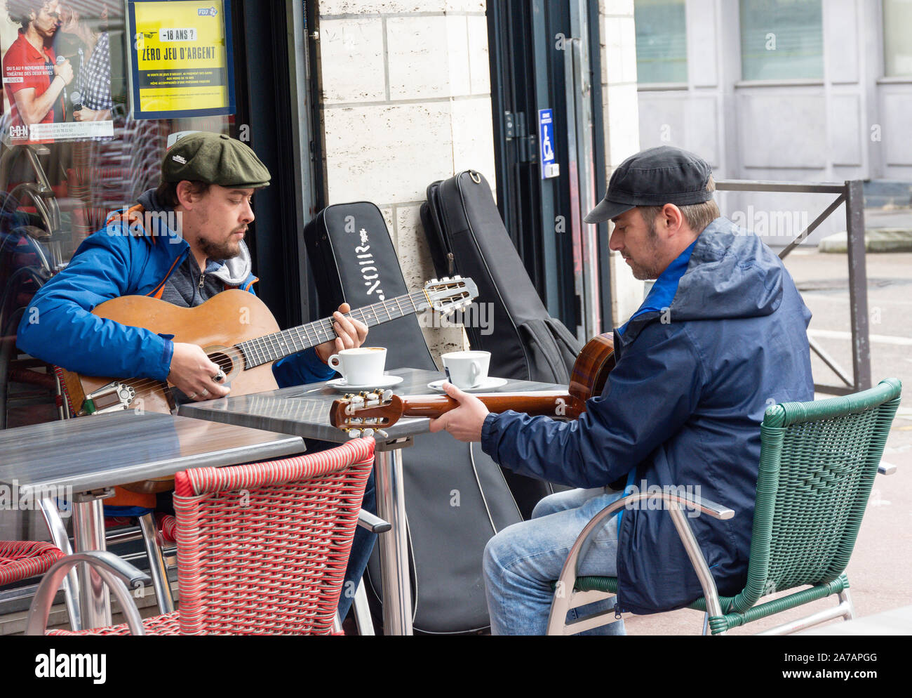 Giovani uomini la riproduzione di chitarre in outdoor cafe, luogo Barthélémy, Rouen, Normandia, Francia Foto Stock