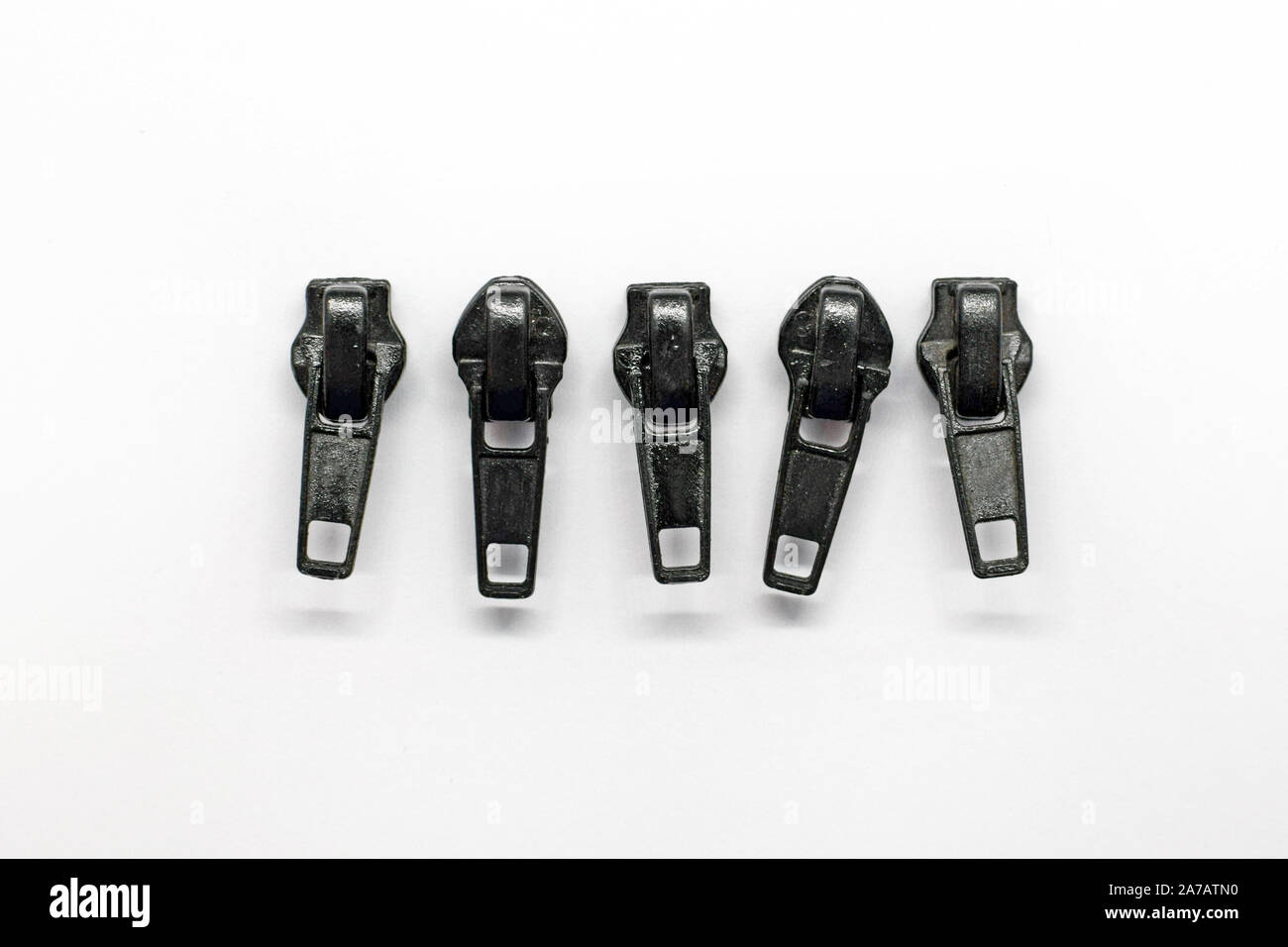 Zipper estrattore per cerniere in nylon, accessori per borse, abbigliamento, scarpe su uno sfondo bianco. Foto Stock