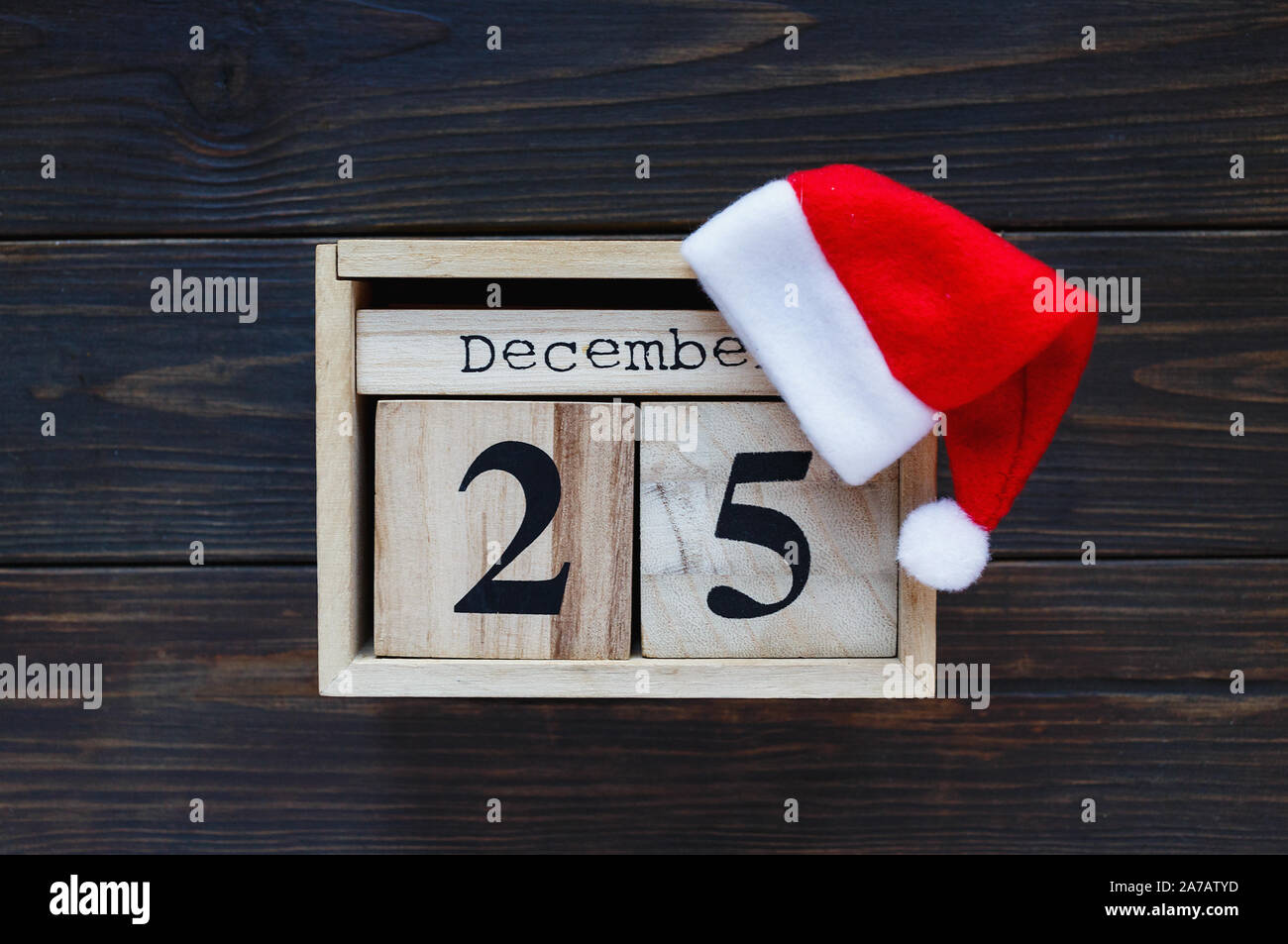 Calendario di legno su sfondo marrone. Nuovo anno e decorazione di Natale, biglietto di auguri mock up. Foto Stock