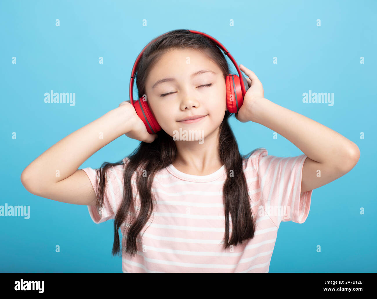 Felice bambina con le cuffie per ascoltare musica Foto Stock