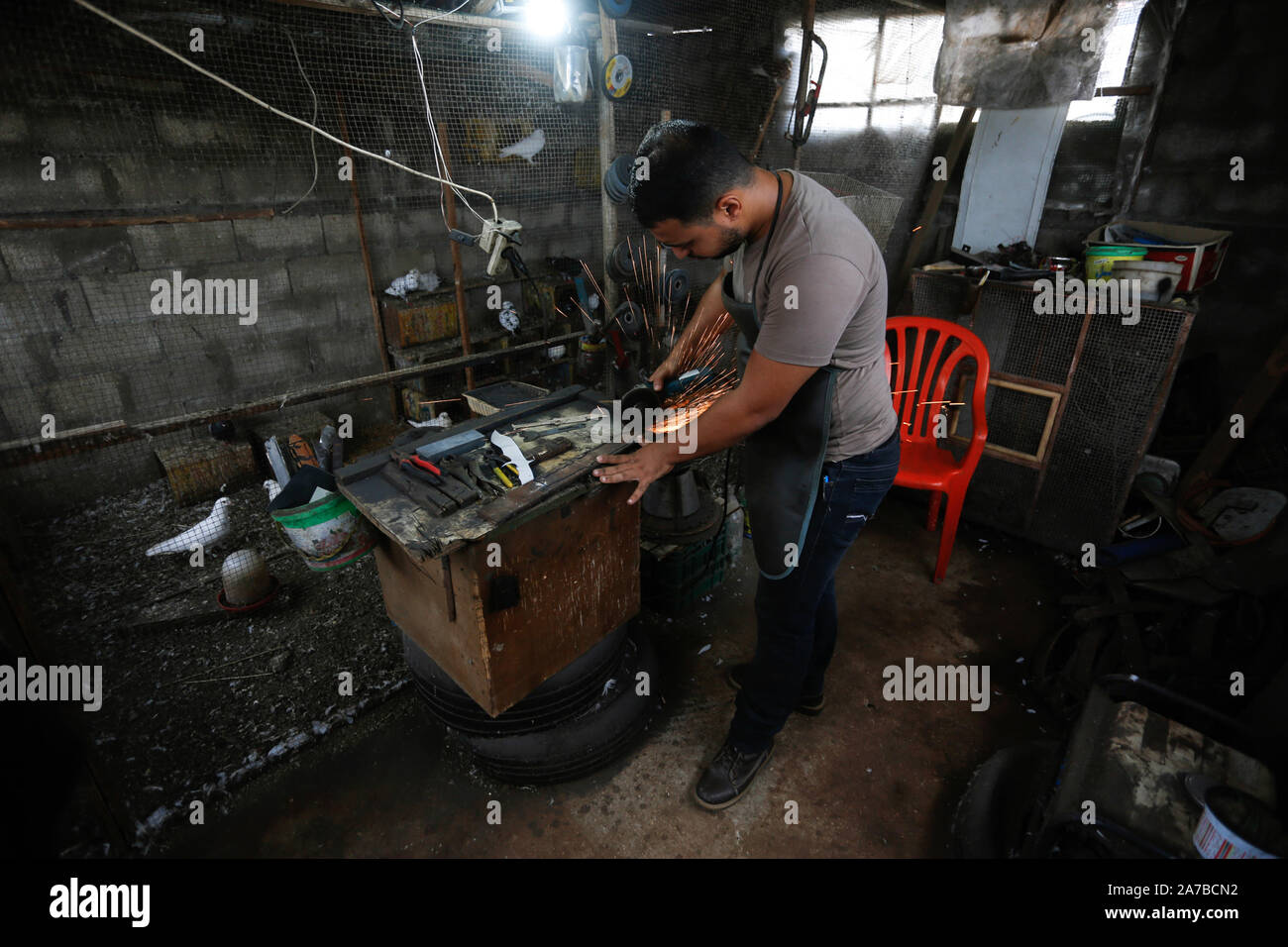 La striscia di Gaza, la Palestina. 29 ott 2019. Saif Abu Azza, di un palestinese di spada e pugnale maker, tagli di ferro-metalli per rendere pugnali presso la sua officina in Khan Younis.La spada e pugnale sono le più antiche armi che un uomo utilizzato per difendersi in tempi antichi e che essi sono considerati come gli antichi strumenti di combattimento. Essi sono utilizzati come gli artefatti e di alcune tribù in diverse religioni che li utilizzano come un simbolico armi. Credito: Yousef Masoud/SOPA Immagini/ZUMA filo/Alamy Live News Foto Stock