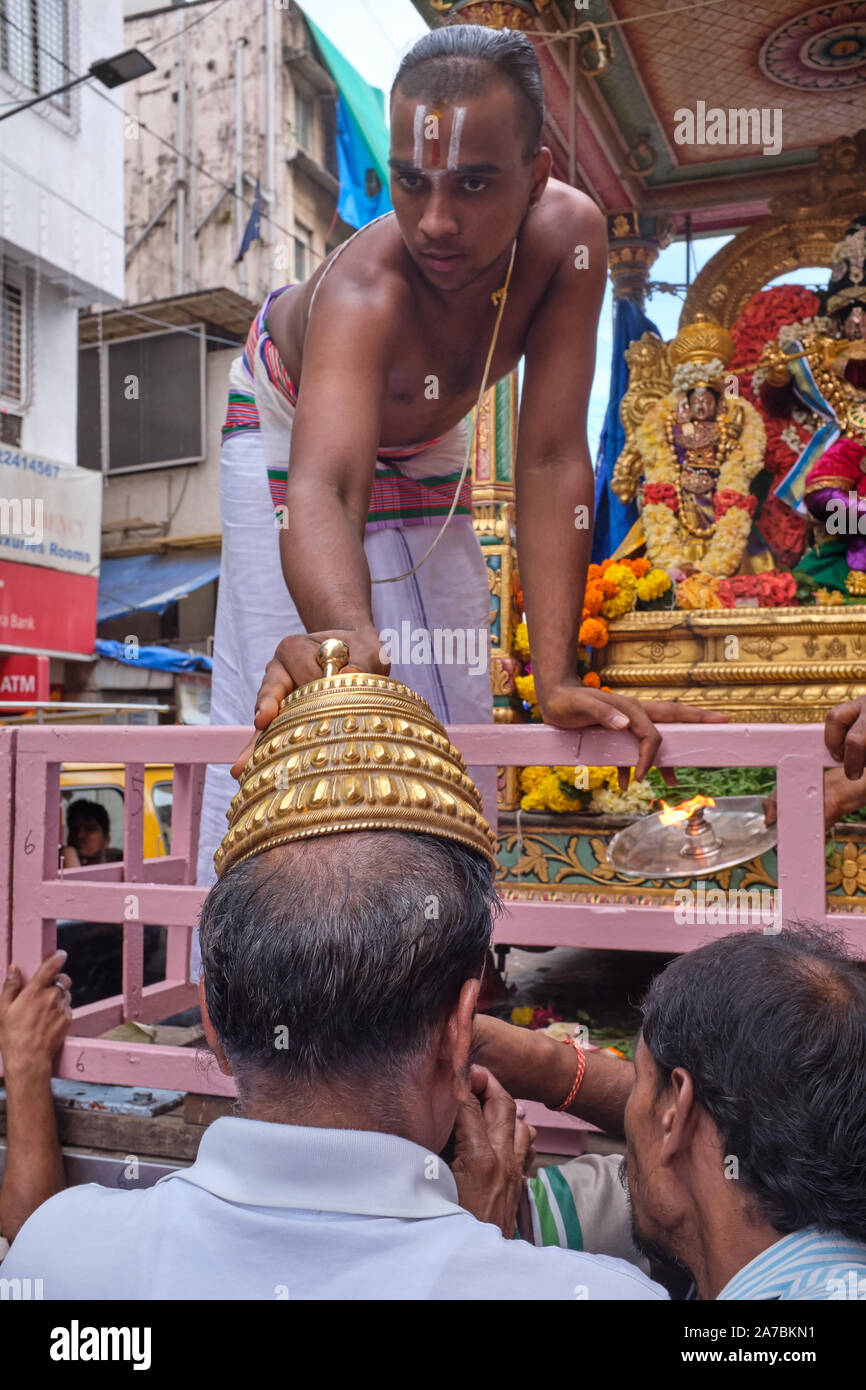 Durante una processione in onore del dio indù Venkateshwara, un sacerdote  pone il dio corona simbolica su una fedele la testa come una benedizione;  Mumbai, India Foto stock - Alamy