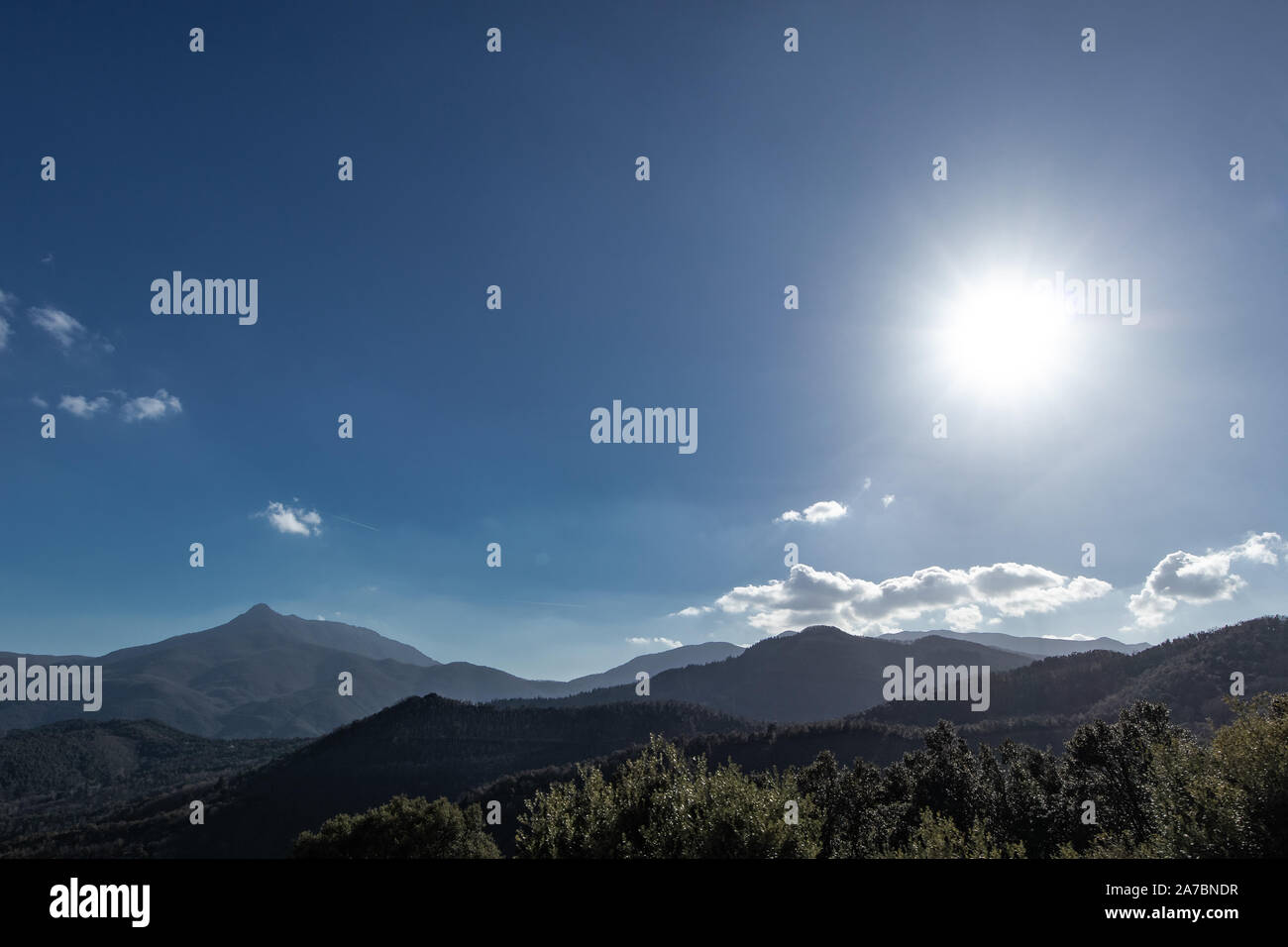 Sole che splende attraverso un cielo blu su Montseny e montagne catalano Foto Stock