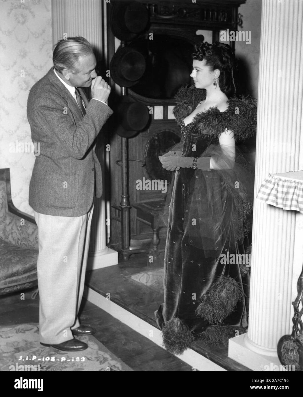 Direttore Victor Fleming e Vivien Leigh in abito rosso vestito come Scarlett O'Hara sul set candida durante le riprese di Via col vento 1939 direttore Victor Fleming romanzo Margaret Mitchell produttore David O. Selznick Selznick International Pictures / Metro Goldwyn Mayer Foto Stock