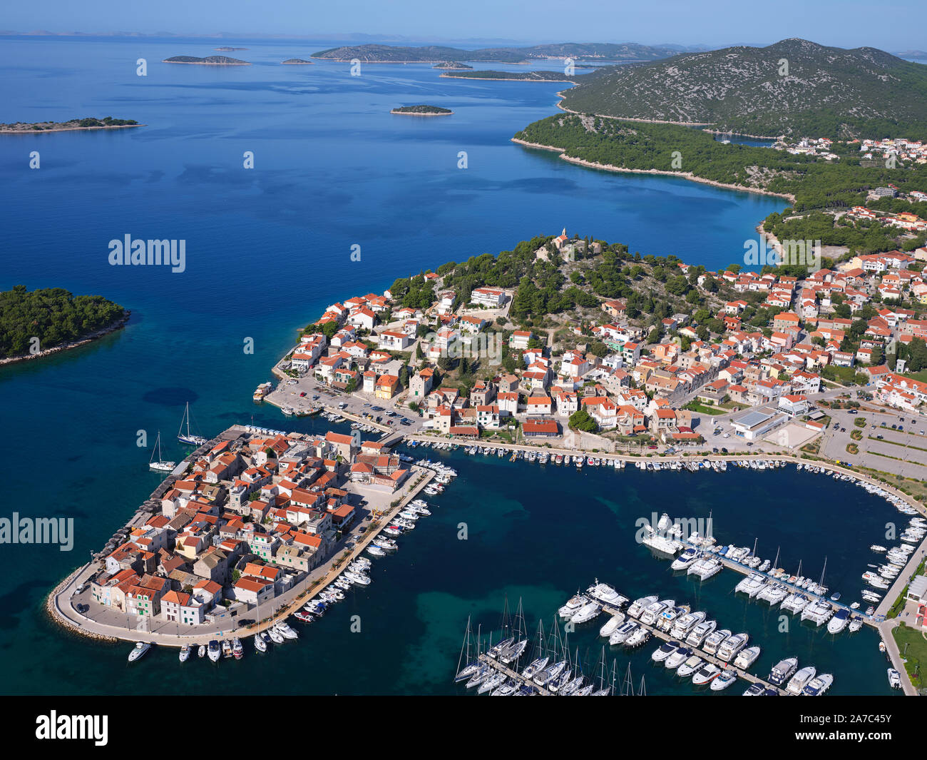 VISTA AEREA. Pittoresca città, penisola e porto turistico di Tribunj. Vicino a Vodice, Contea di Šibenik-Knin, Dalmazia, Croazia. Foto Stock