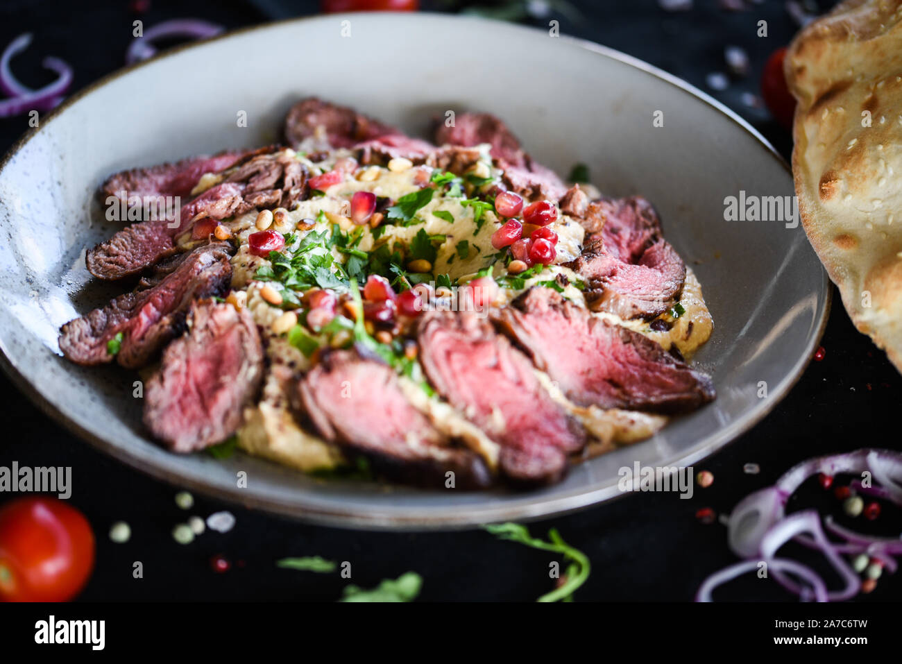 hummus libanese con carne di manzo arrosto e semi di melograno Foto Stock