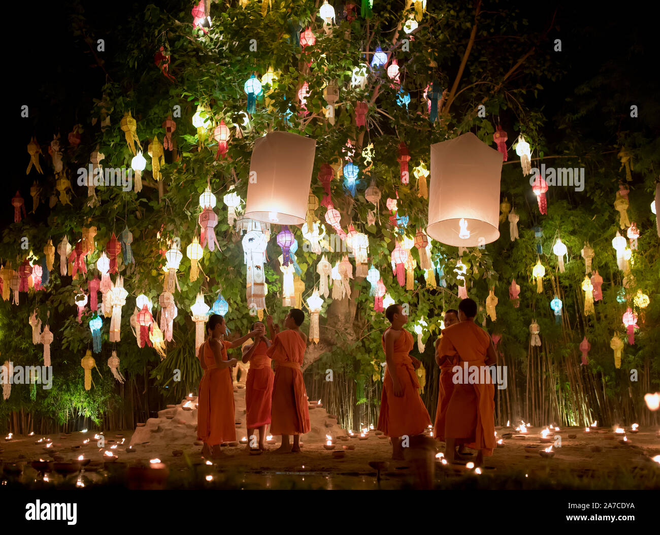 Linea di monaci con luci di candela celebrando Loy Krathong festival. Chiang Mai, Thailandia Foto Stock