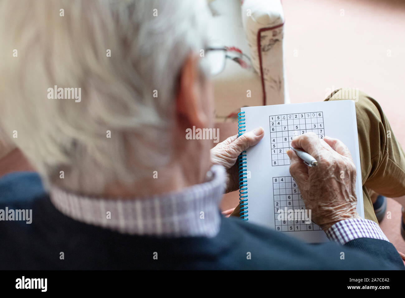 Senior uomo facendo Sudoku Puzzle a casa Foto Stock