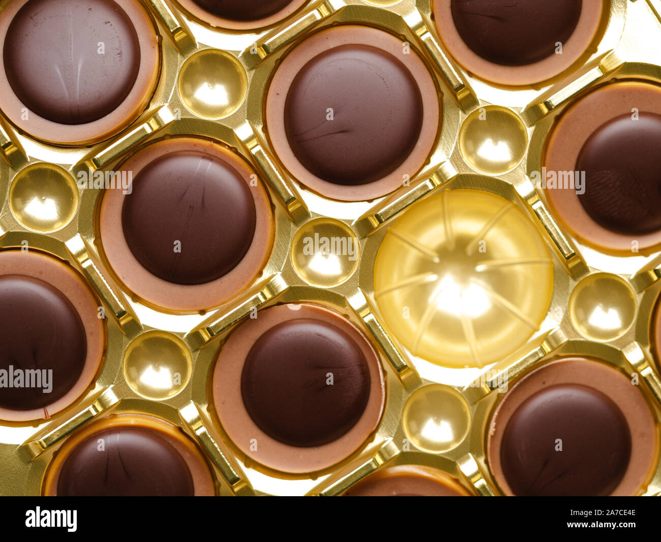 Cioccolatini con uno mancante in una scatola dorata, vista dall'alto Foto Stock