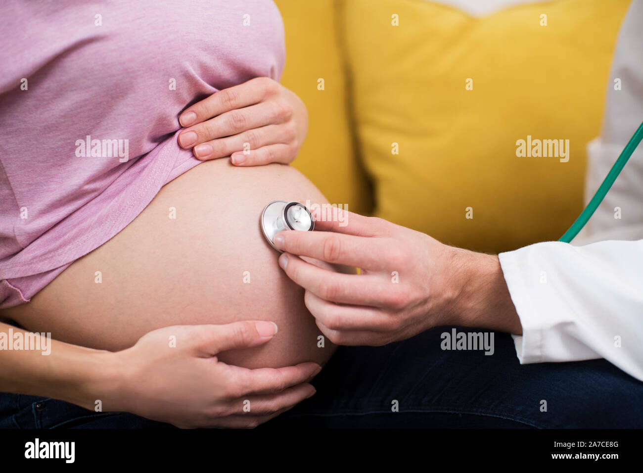 Close up medico utilizzando uno stetoscopio per esaminare la donna incinta Foto Stock