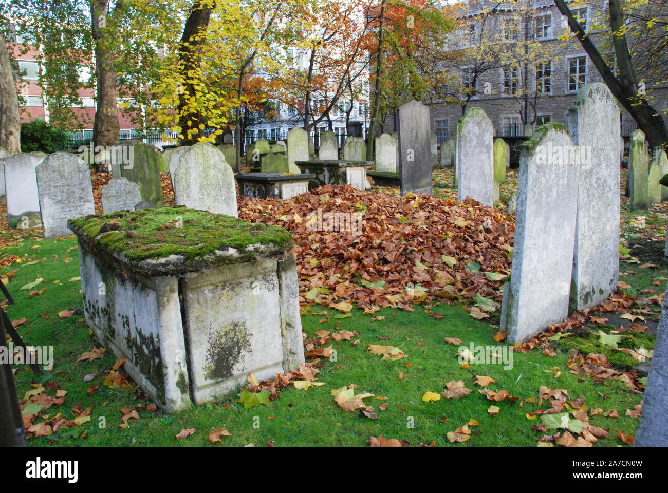 Autunno antico cimitero con foglie di colore arancione e verde erba in Inghilterra. Spooky vecchio cimitero per temi di Halloween e decorazione. Foto Stock