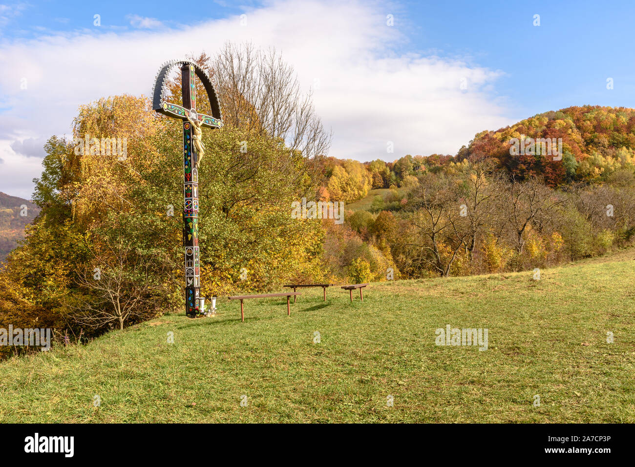Un crocifisso sul ciglio della strada che si affaccia sul villaggio di Muran in Slovacchia in autunno Foto Stock